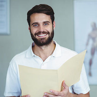 Male Chiropractic Nurse Smiling - Lead Image for Chiropractor Office Page