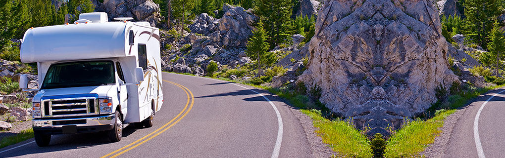 Inszone Insurance RV Insurance Page Banner - Vehicle Cruising Mountain Highway