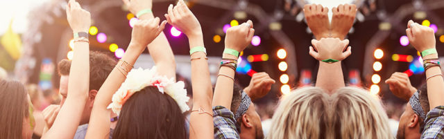 Crowd Raising Hands While Watching Concert - Lead Image for Festivals Page