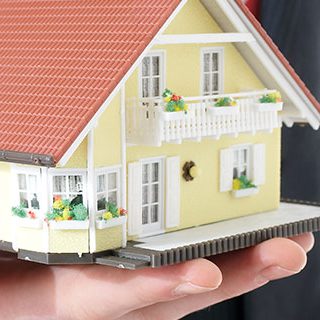 Man Holding Toy Model House - Lead Image for Condominium and Home Owners Associations Page